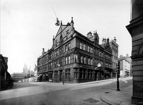 14th October 1928. Image shows the corner of Albion Street and Guildford Street with the Commercial Hotel on the corner, and Guildford chambers to the left. The road was renamed as The Headrow after widening took place in the 1930s but this section was formerly known as Guildford Street. In the background, left, building work is in progress on the Leeds Permanent Building Society site, Permanent House, at the corner with Cookridge Street, now part of The Light. Text and image taken from Leodis
