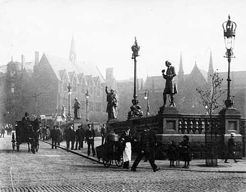 Undated. An early view of City Square with the spires of Mill Hill Chapel beyond on the right. City Square was designed to commemorate Leeds receiving city status in 1893 and the statues seen here were chosen to celebrate this. From the far left, James Watt (1736-1819) by Henry Charles Fehr for his effect on the industry by his improvements to the steam engine. Second from left, John Harrison also by Henry Charles Fehr, an influential figure in seventeenth century Leeds, endowed St John's Church. Walter Farquhar Hook, by Frederick Pomeroy, known as 'The Great Vicar of Leeds' and right Joseph Priestley by Alfred Drury, discoverer of oxygen. Taken from www.leodis.net