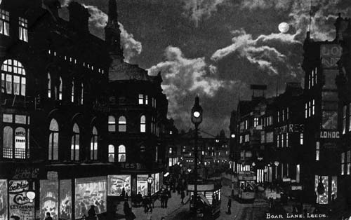 View of Boar Lane by night from a postcard with postdate 23 February 1904. The view looks east with Lockhart's Cafe on the left and London Dentistry and the Grand Restaurant on the right.