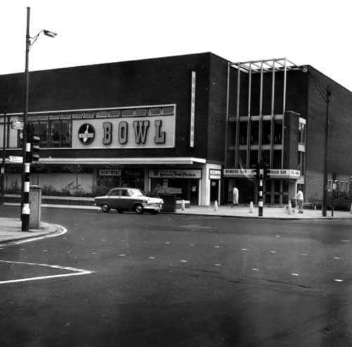 June 1967. View shows Arndale House and Carlines Supermarket. A lorry is unloading in the street. There are cars and a second lorry on the street.