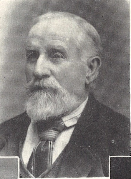 Photograph of James Bywater, a bearded middle-aged man, wearing a smart suit and tie.