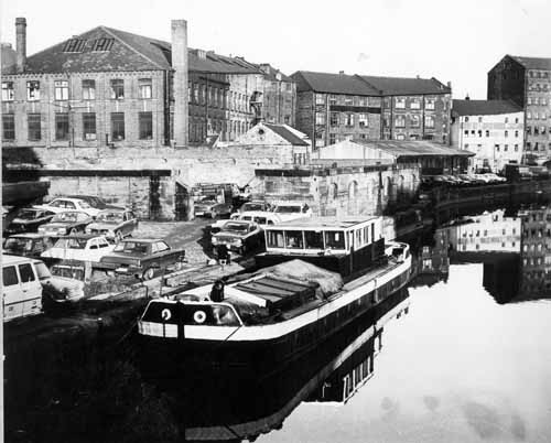 c1978. View from Leeds Bridge looking downstream, east, to former warehouses on the River Aire. From www.leodis.net, (c) Leeds Library and Information Service
