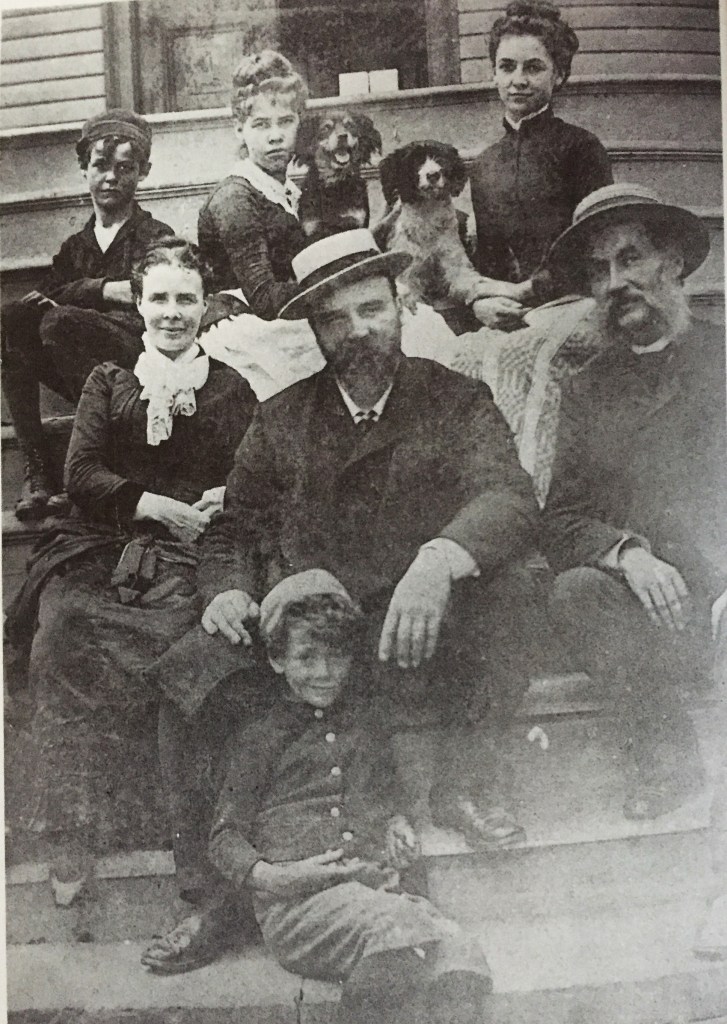Photograph of seven people, including two children, plus two dogs