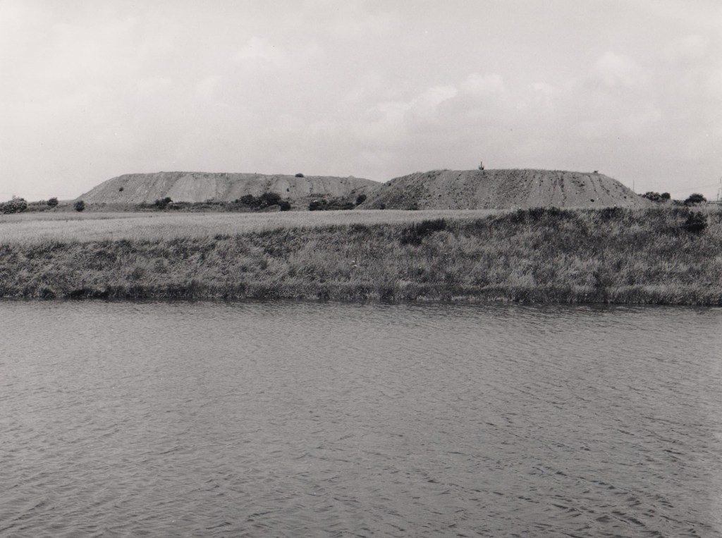 View of a lake with hills in the background used for open cast mining.